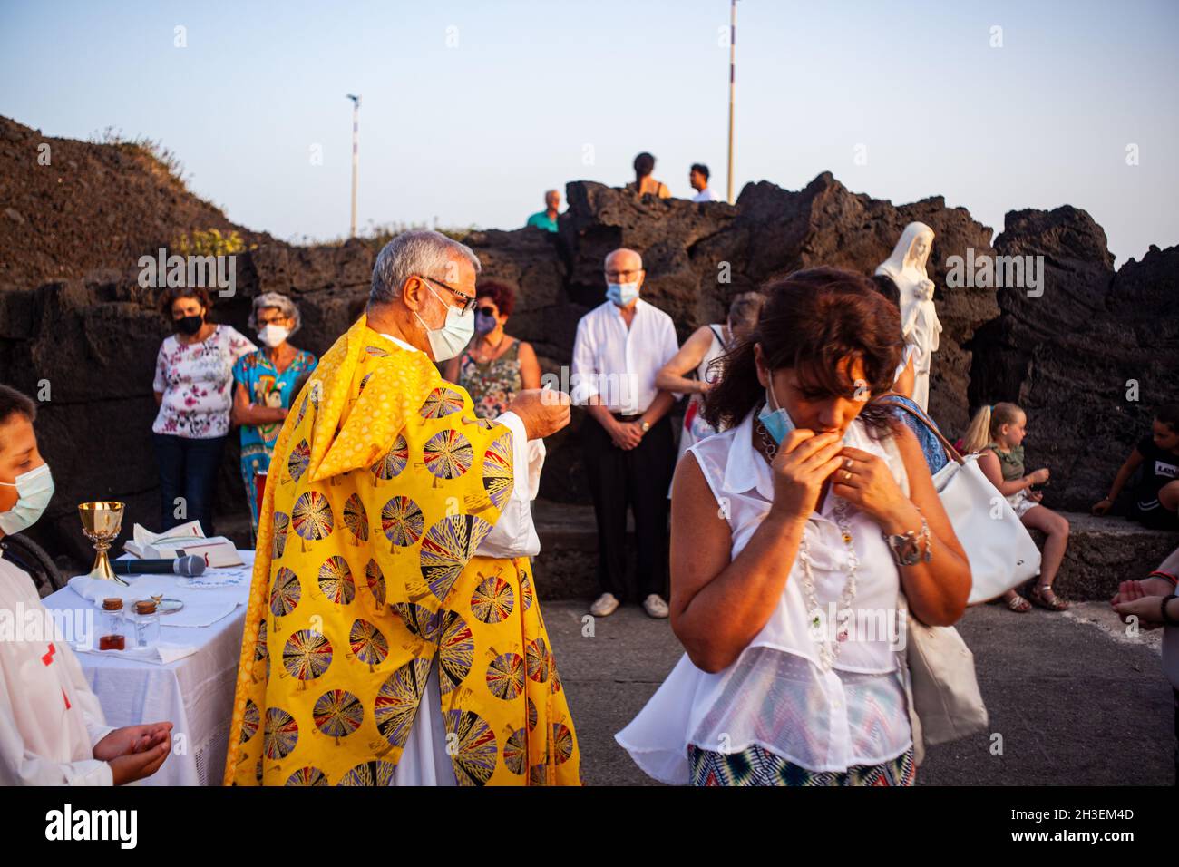 Linosa, Italy - July 25: Priest give host at faithful in the Procession of the Stella Maris during the religious patronal feast of the Madonna of the Stock Photo