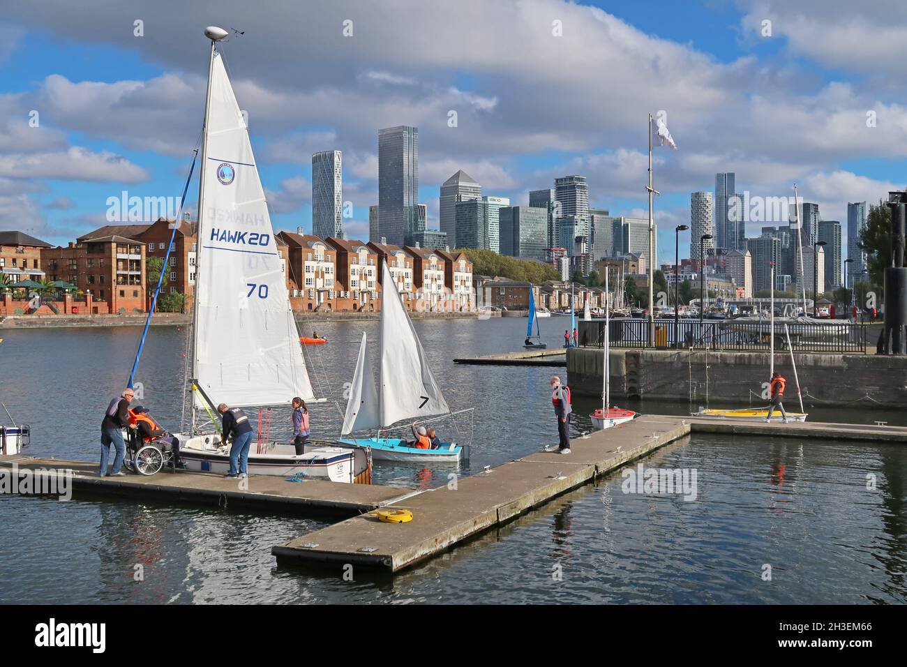 A disabled man is helped to a sailing boat  at Greenland Dock Watersports Centre, part of the old Surrey Docks in Rotherhithe, London, UK. Stock Photo