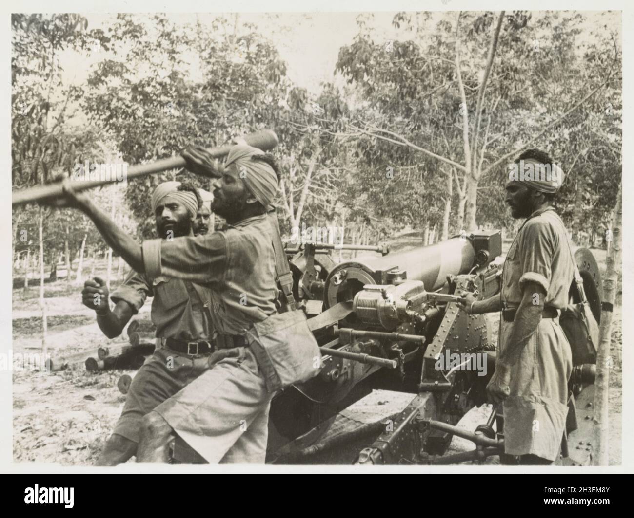 A vintage photo circa 1941 of Sikh soldiers of the Indian Army manning an artillery gun in the jungle prior to the Japanese invasion of Malaya and the fall of Singapore Stock Photo