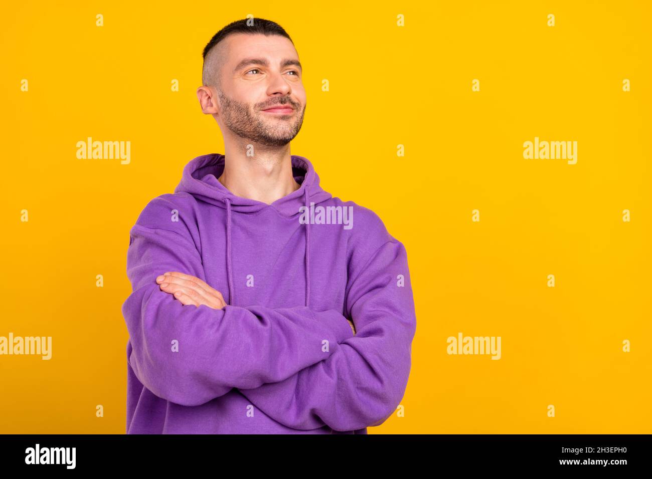 Portrait of attractive dreamy content cheerful guy folded arms thinking copy space isolated over vivid yellow color background Stock Photo