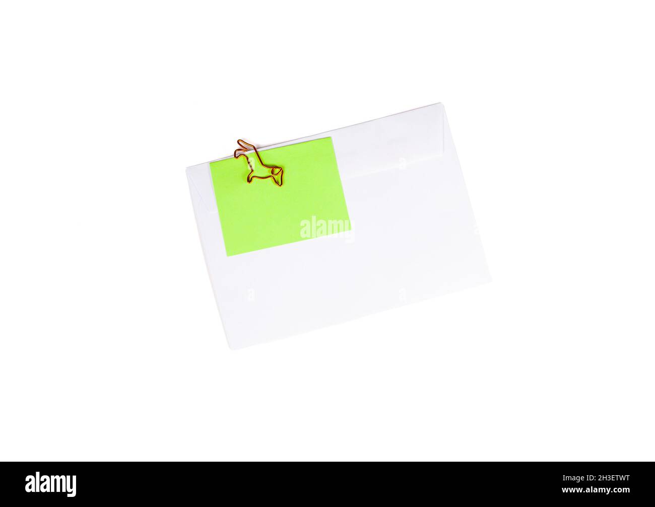 Paper envelope with blank note and dog-shaped paper clip on white background. Office supplies for a good mood. reminder on paper. Close up Stock Photo