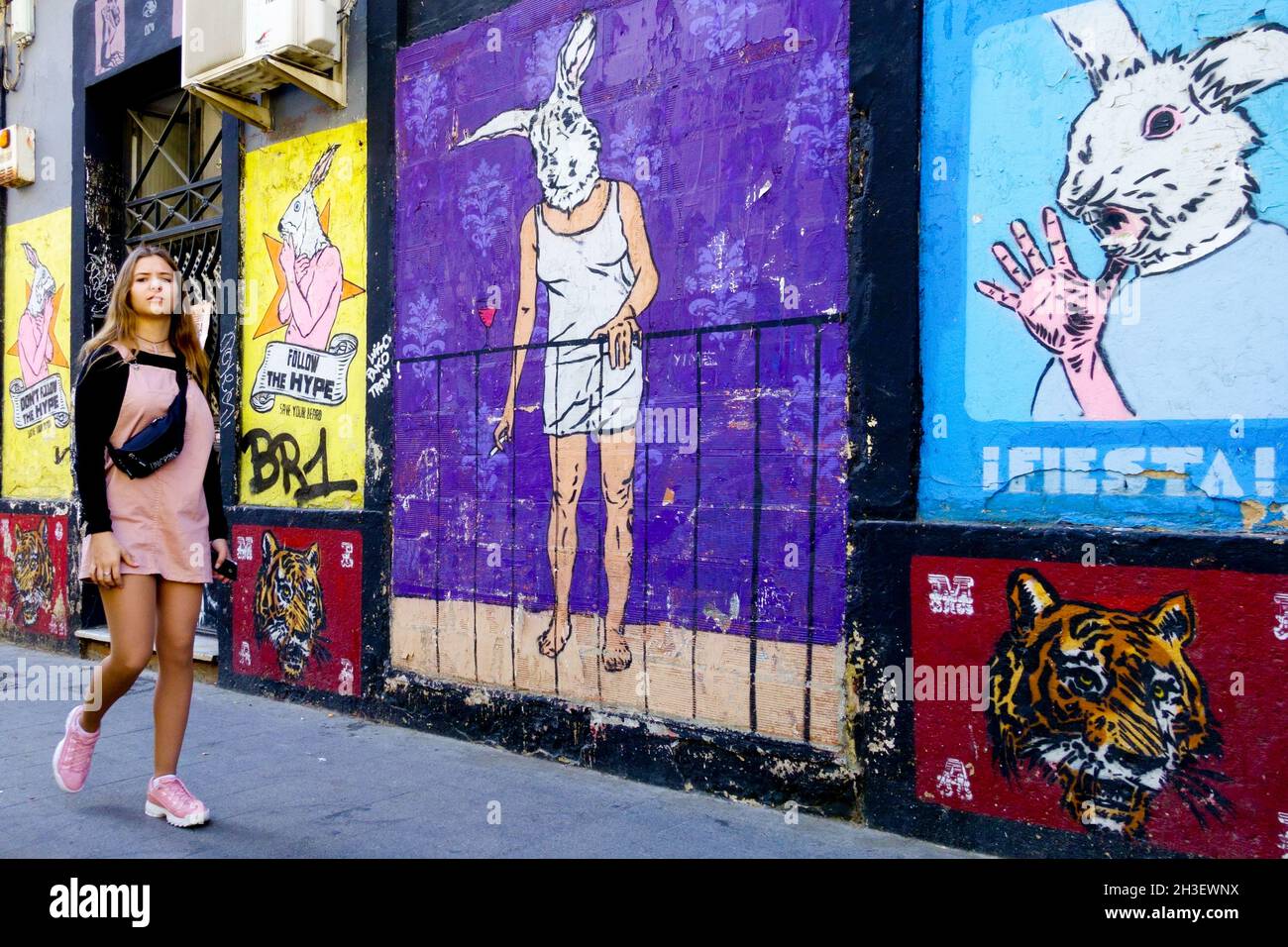 Ruzafa Valencia girl passing along graffiti wall, mural street art Spain rabbit street city Stock Photo