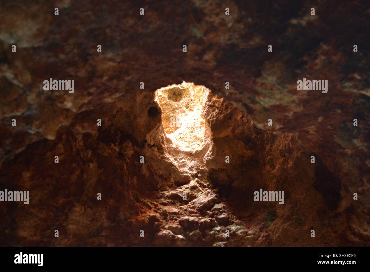 Sunlight Shining Through Hole in Roof of Cave in Cala Blanca Stock Photo