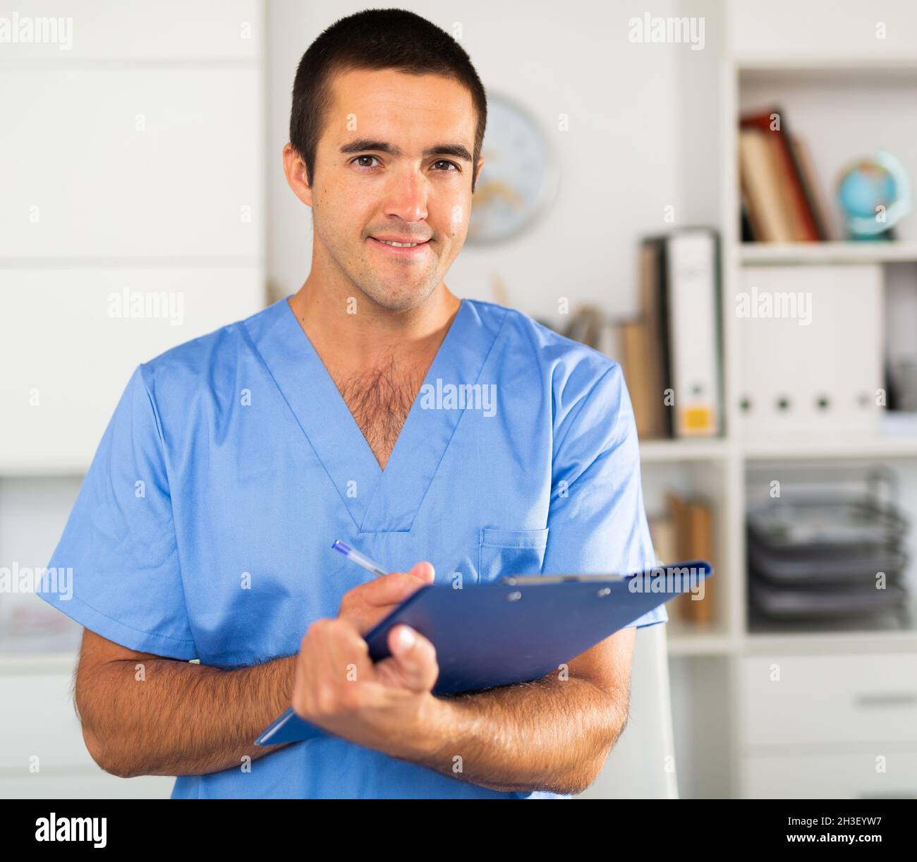 Male nurse filling out medical form on clipboard Stock Photo Alamy