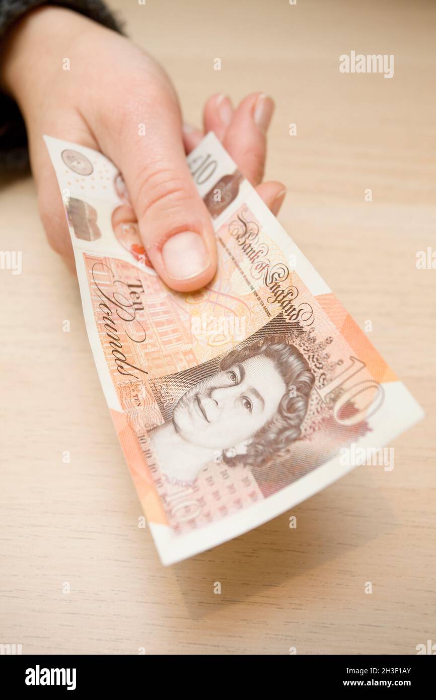 Ten pound note in hand. uk Stock Photo