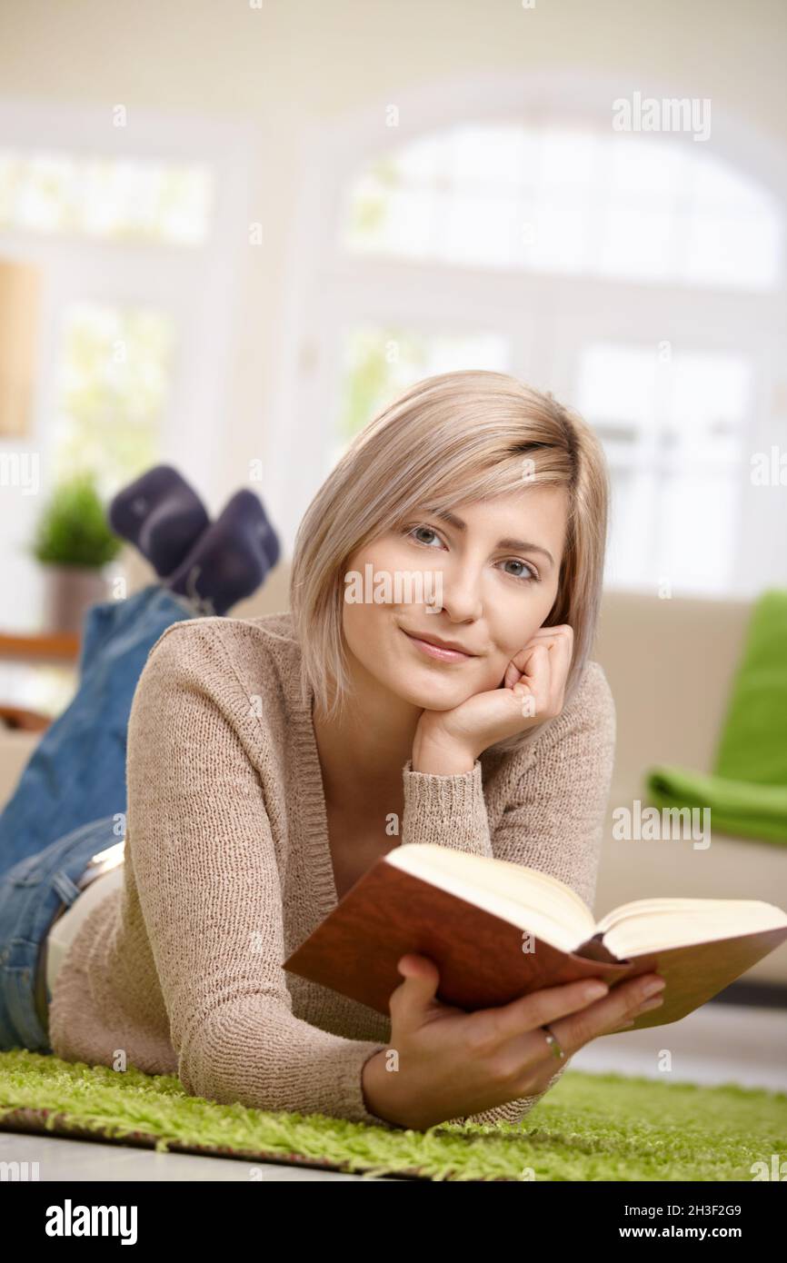 Smiling woman reading book Stock Photo