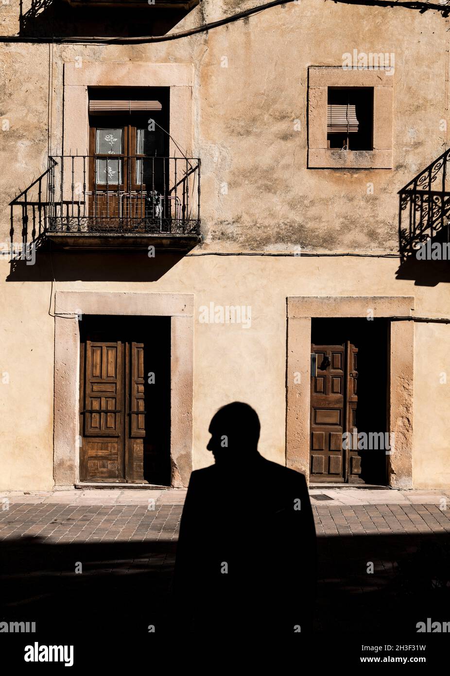 Silhouette of adult man in front of facade of an old building in Sepulveda, Spain Stock Photo