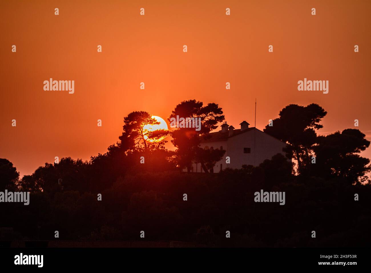 SUECA, SPAIN - Sep 28, 2021: A fascinating view of trees and a house at colorful sunset. Stock Photo