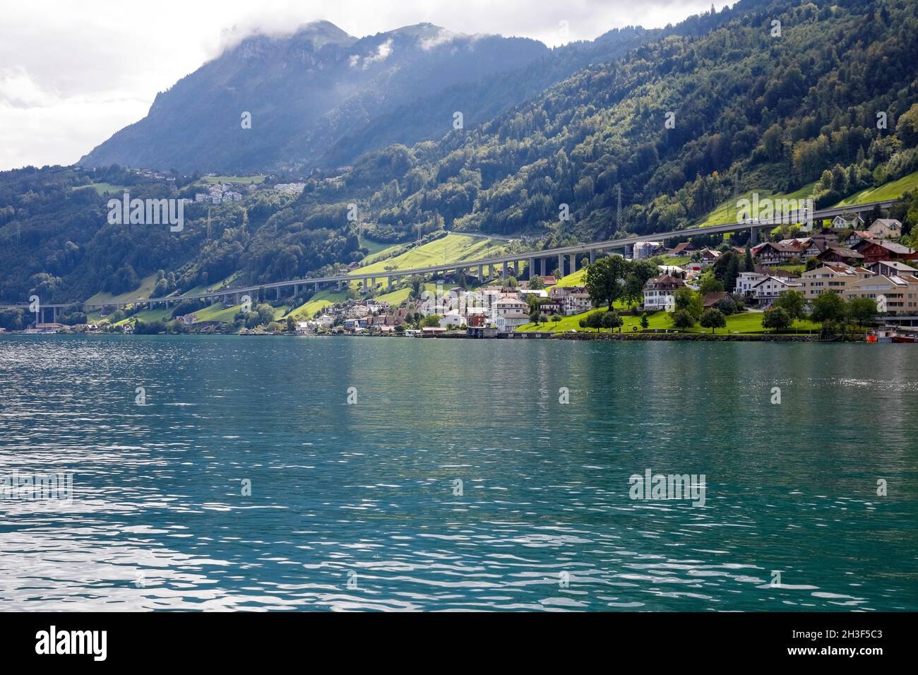 Residential buildings located on the slope of the hill on the edge of Lake Lucerne are visible at a distance. The Lake of the four Cantons. Stock Photo