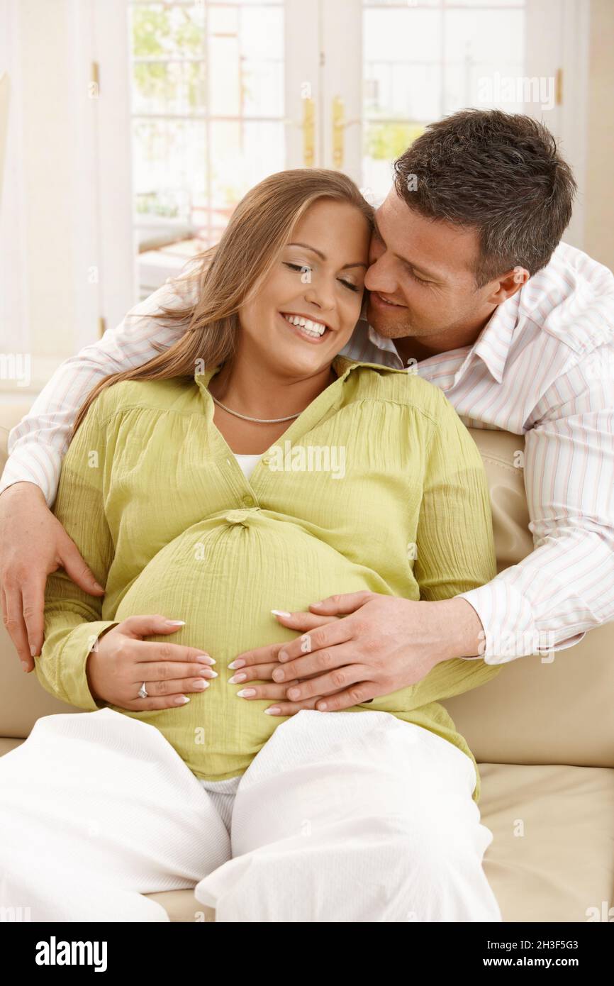 Man embracing pregnant woman Stock Photo - Alamy