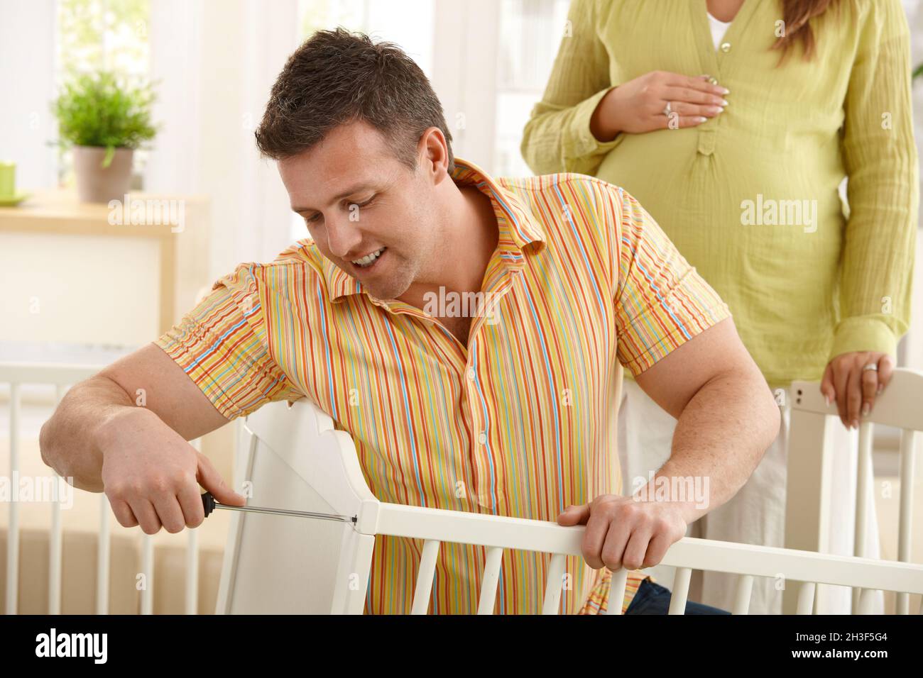 Dad fixing baby's bed Stock Photo Alamy