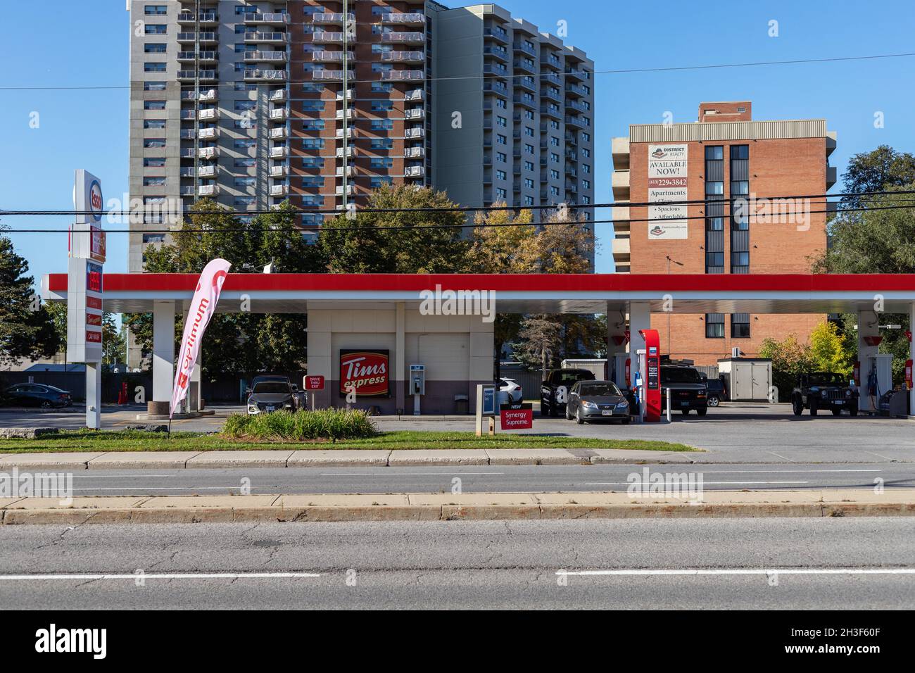 Ottawa, Canada- October 6, 2021: Esso gas station sign with Tim Hortons express shop and apartment buildings in background Stock Photo