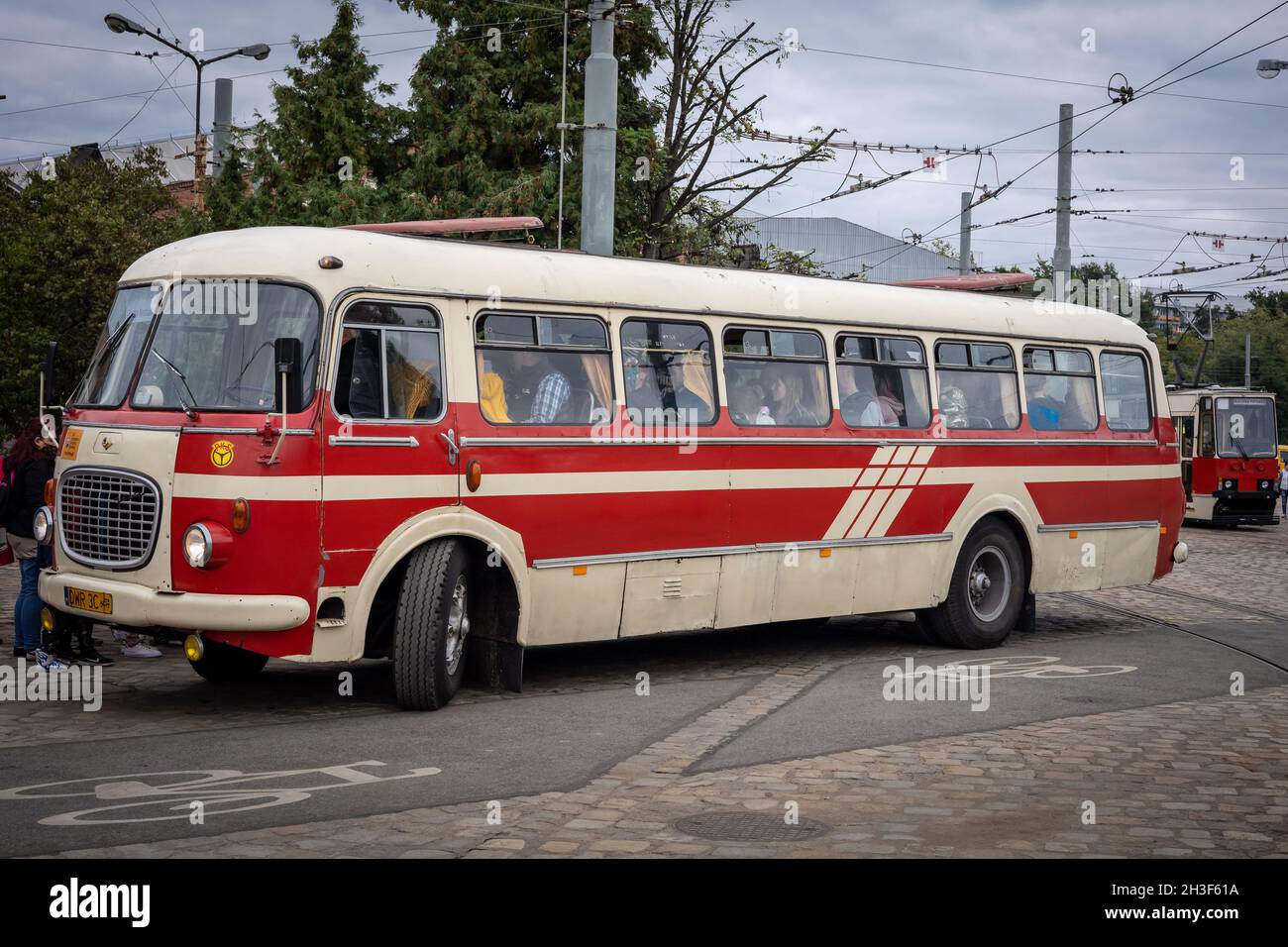 Wroclaw, Poland - September 19, 2021: A vintage red and cream Skoda bus at the bus stop, with passengers sitting inside. Stock Photo