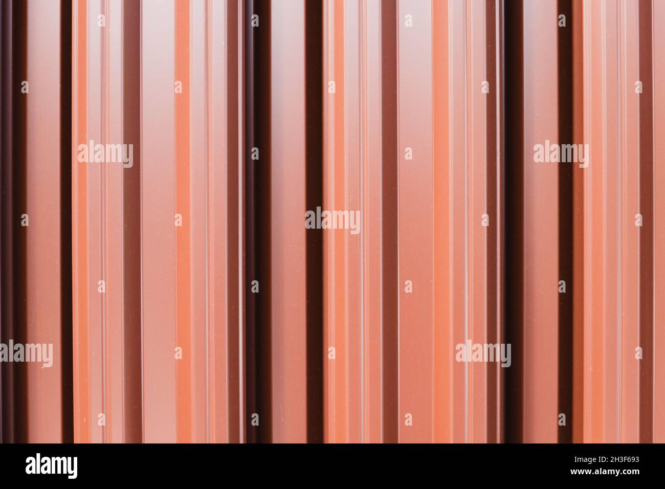 Shiny fence made of red metal planks, abstract background photo texture Stock Photo