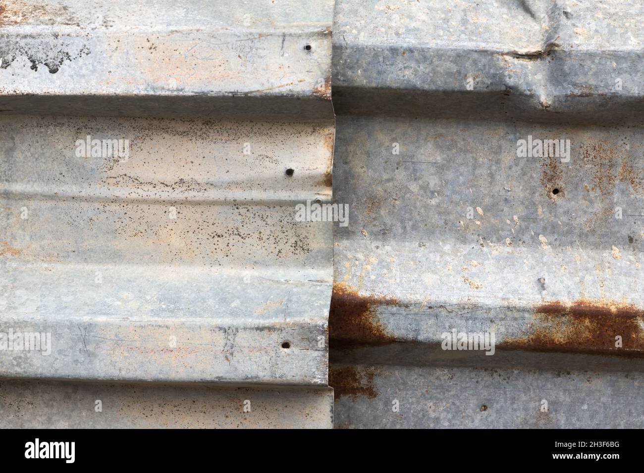 Old gray corrugated metal fence with rust spots, frontal background photo texture Stock Photo