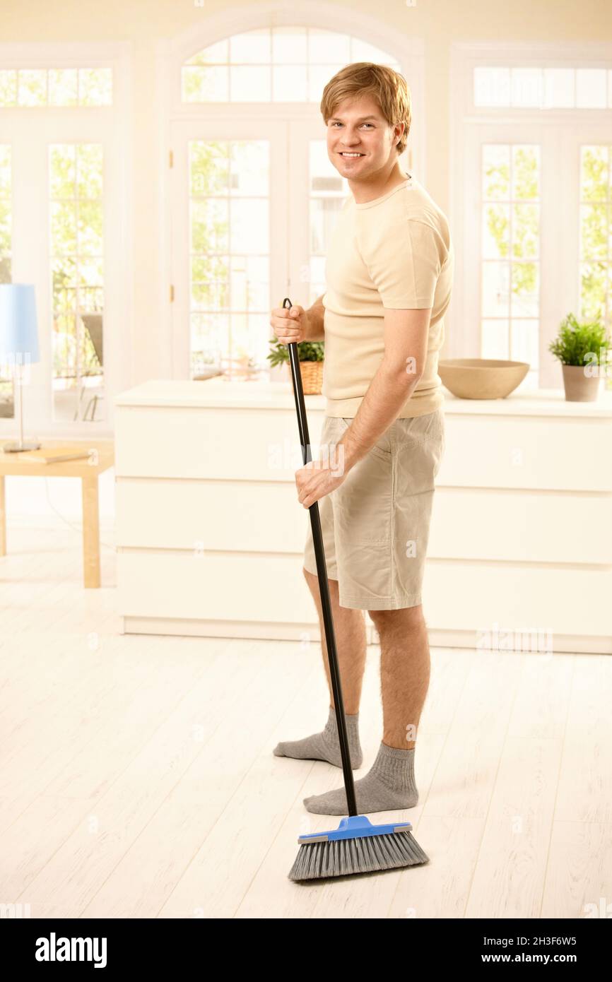 Guy sweeping the floor Stock Photo - Alamy