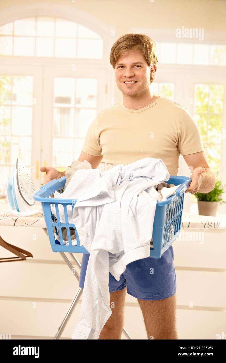 Man holding laundry full clothes hires stock photography and images
