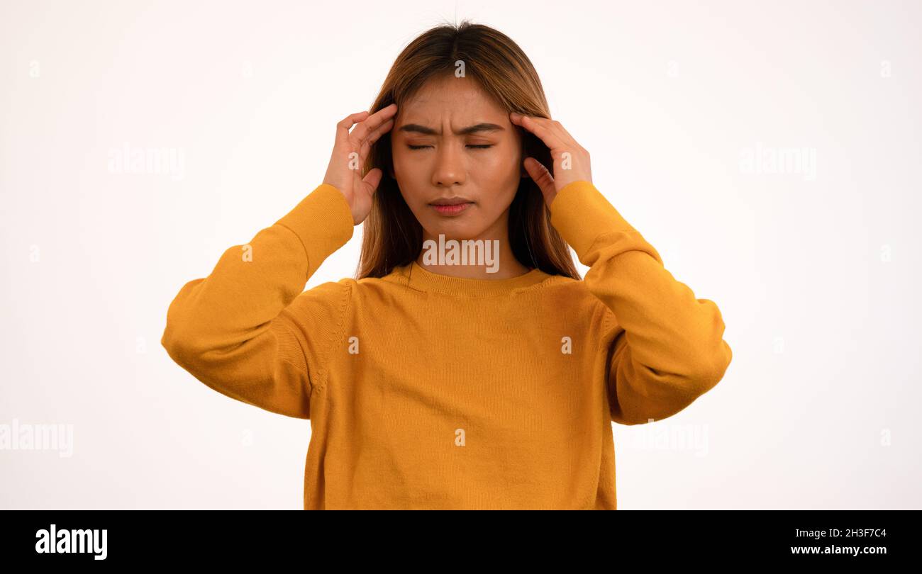 Young attractive asian woman with headache in studio Stock Photo