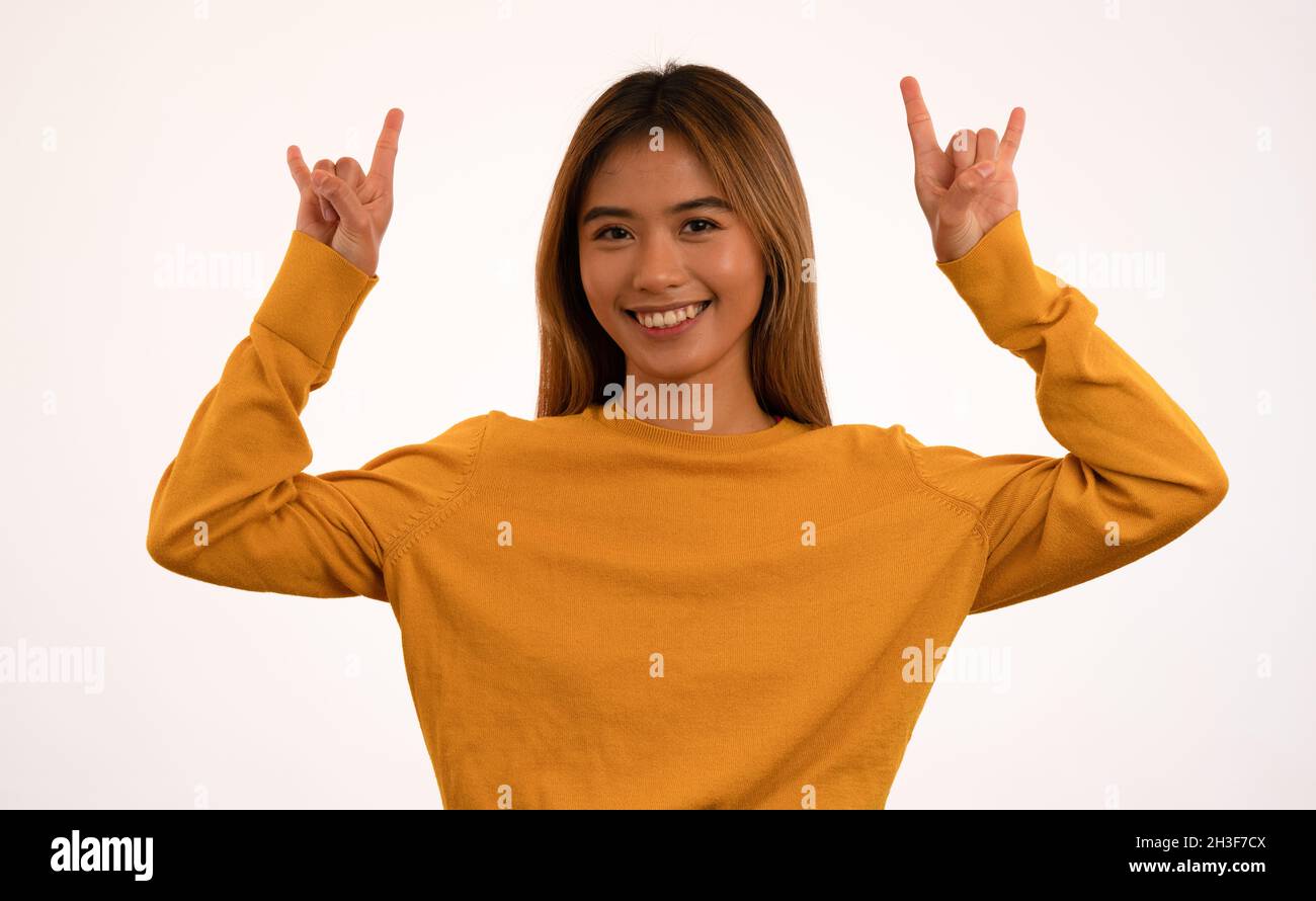 Young attractive asian girl smiling with rock n roll pose in studio Stock Photo