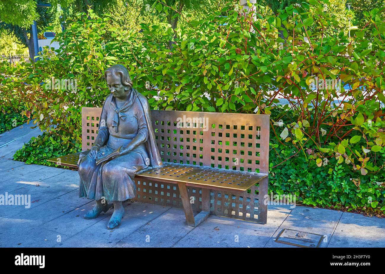 GRANADA, SPAIN - SEPT 27, 2019: The monument to the famous Spanish poet Elena Martin Vivaldi, sitting on the bench among the greenery, Constitution Av Stock Photo