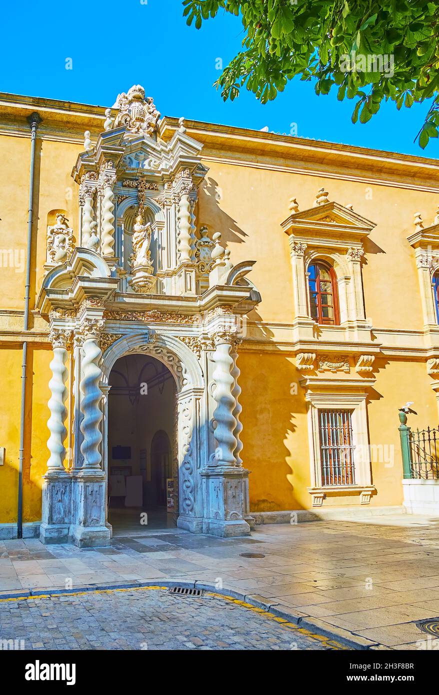 The ornate portal of medieval building of Faculty of Law of Granada University with white marble sculptures, garlands and twisted Solomonic columns, G Stock Photo