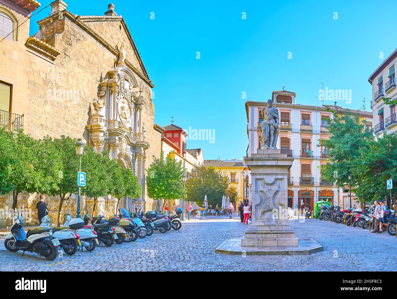GRANADA, SPAIN - SEPT 27, 2019: The monument to King Carlos V and Basilica of San Justus and Pastor, University Square, on Sept 27 in Granada Stock Photo