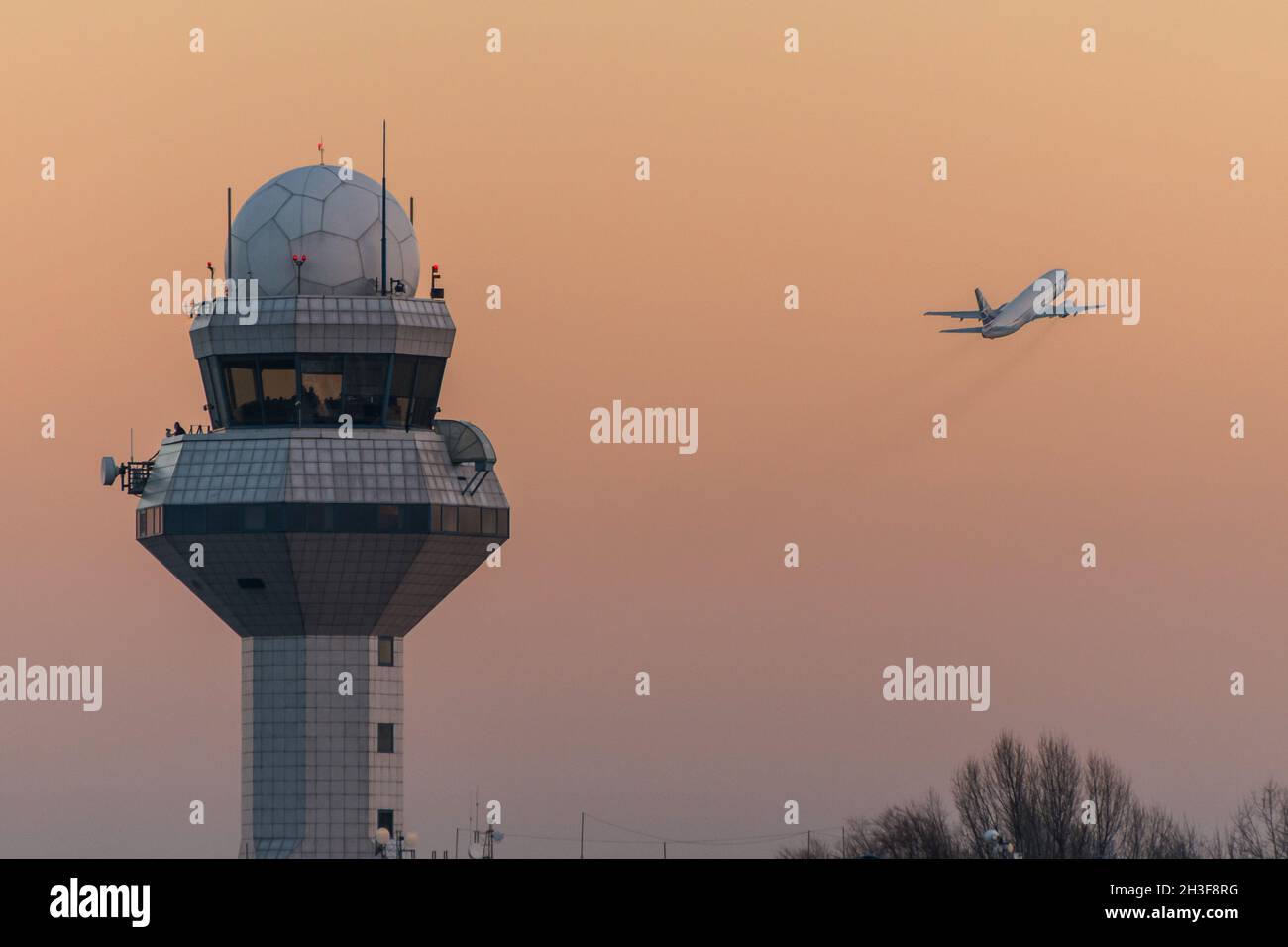Warsaw, Poland - December 28, 2013: Late afternoon air traffic control tower and start of LOT Polish Airlines Boeing 737 jet plane at Chopin Airport Stock Photo