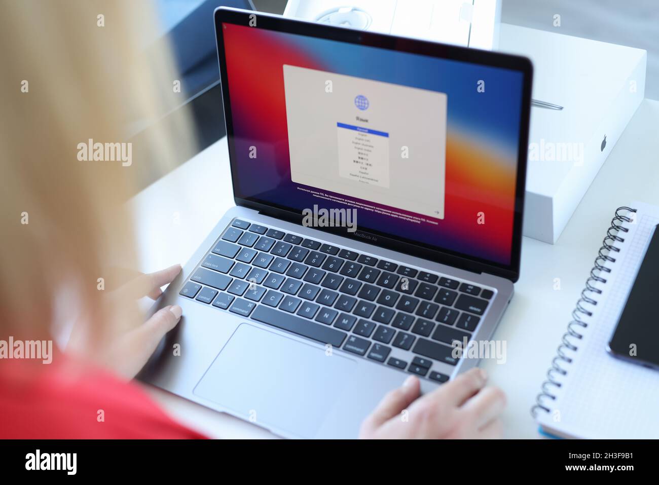 Woman choosing language on new laptop Apple MacBook air closeup Stock Photo