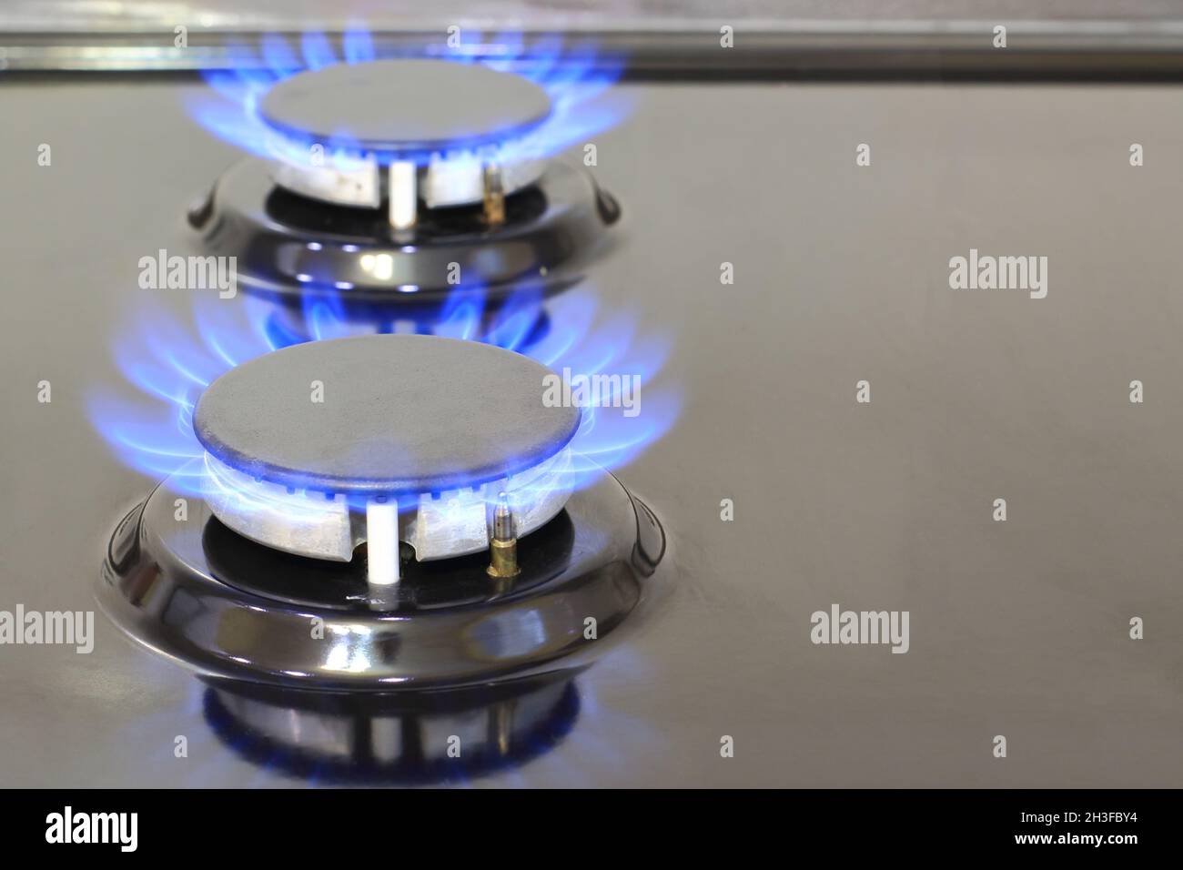 Gas cooker with burning flames of methane or propane gas. Modern kitchen stove cook with blue