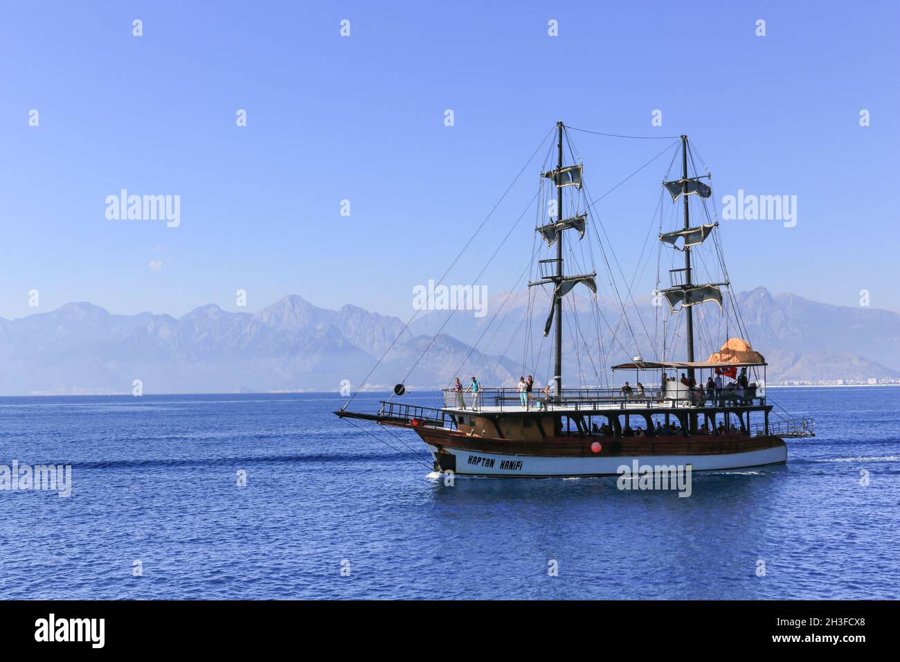 The tourist boat Kaptan Hanifi is heading southeast along the Antalya coast in southern Turkey with a group of tourists on a sightseeing cruise. Stock Photo