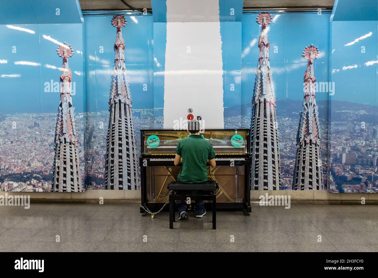 Person playing the piano in the lobby of the Sagrada Familia Metro station in Barcelona, Catalonia, Spain Stock Photo