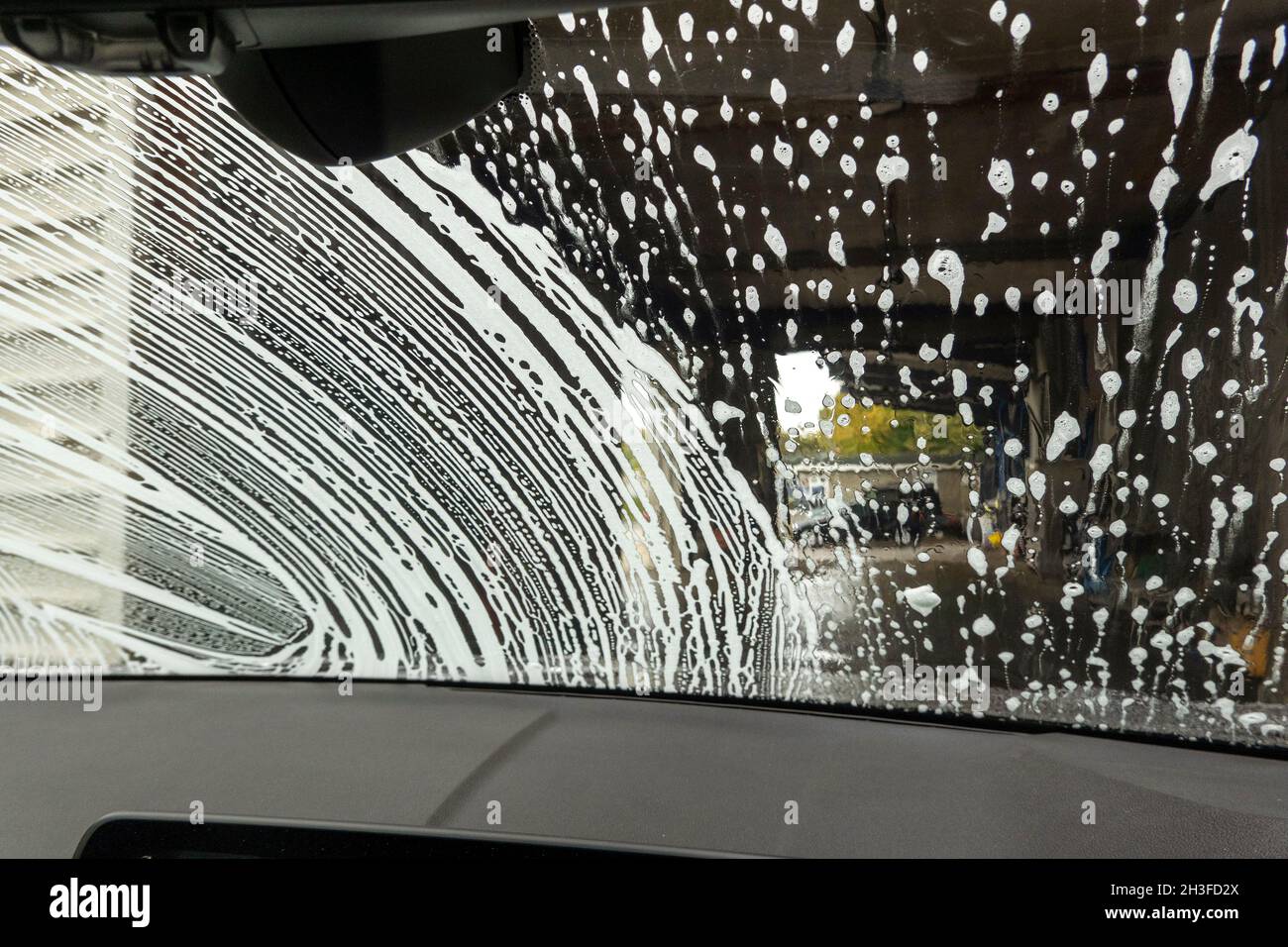 Winchester, Hampshire, UK. 2021. Drivers eye view of soap suds and water during a car wash Stock Photo