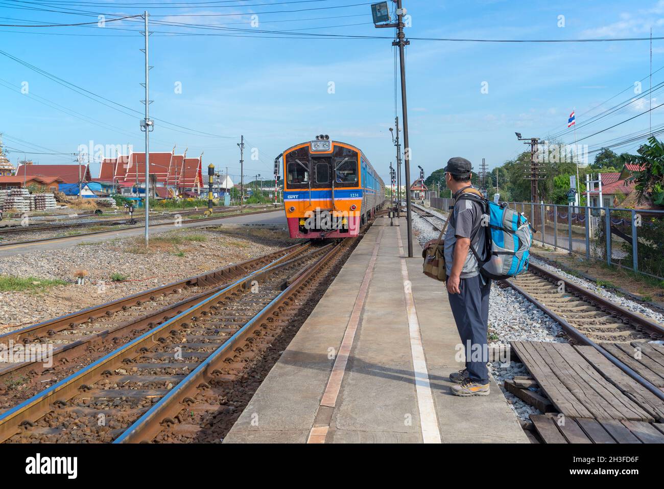 AYUTTHAYA, THAILAND - JANUARY 02, 2017: Backpacker tourist awaits the arrival of the train on the railway platform Stock Photo