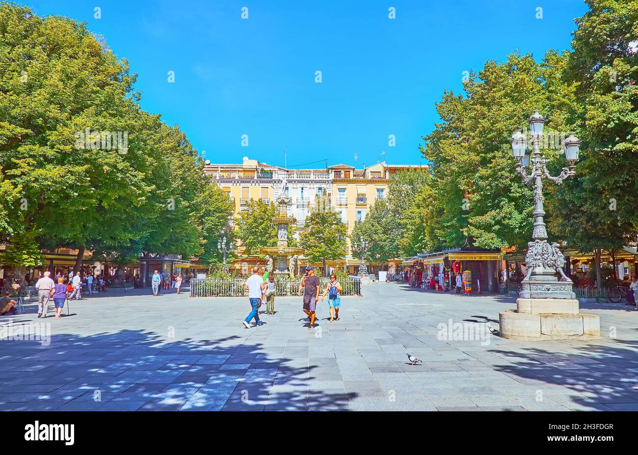 GRANADA, SPAIN - SEPTEMBER 27, 2019: The lush greenery in pedestrian Bib-Rambla square, famous for its Fuente de los Gigantes (Giants Fountain), on Se Stock Photo