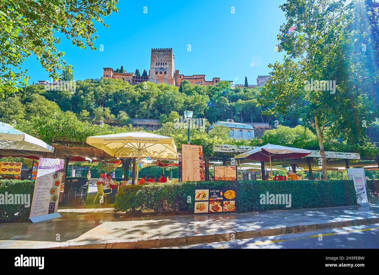 GRANADA, SPAIN - SEPT 27, 2019:  The cozy outdoor restaurant in green park of historic Paseo de los Tristes street of Albaicin neighborhood, on Sept 2 Stock Photo