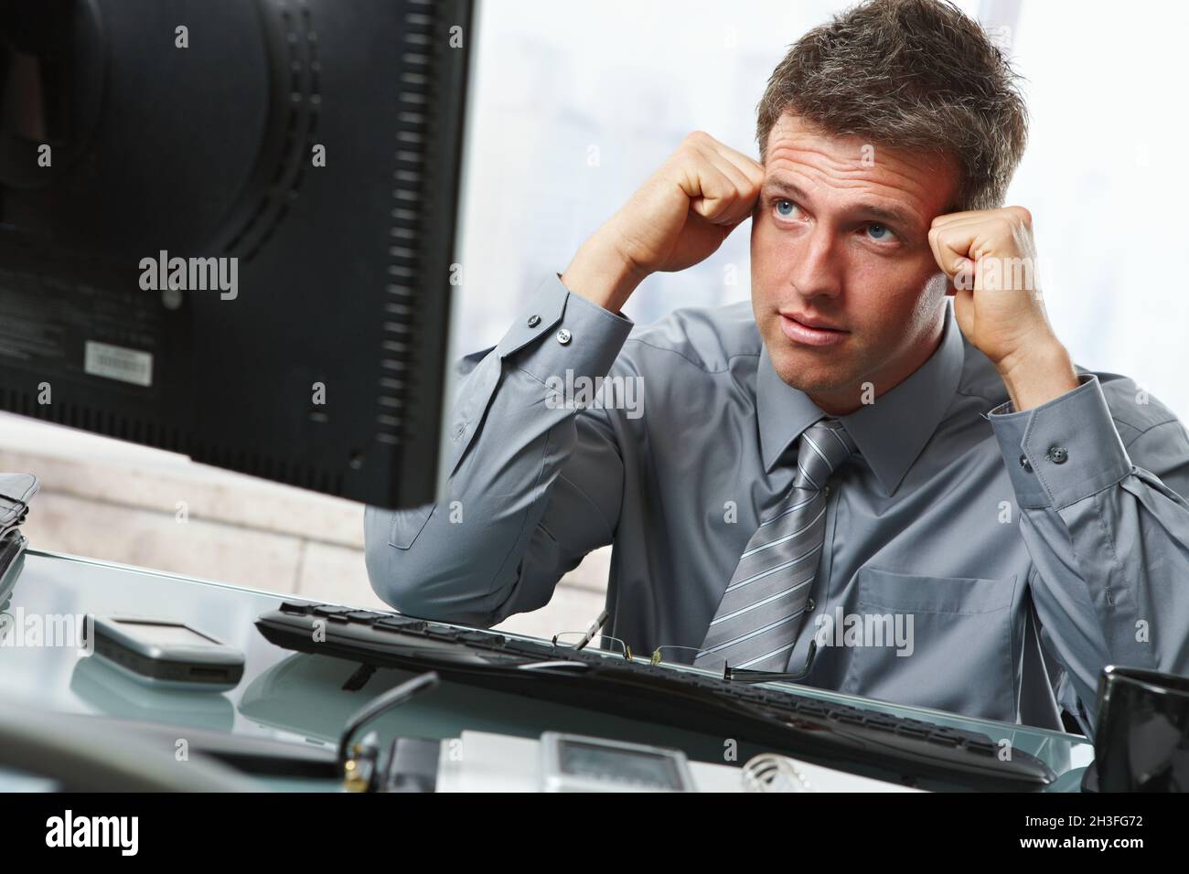 Businessman thinking at desk Stock Photo