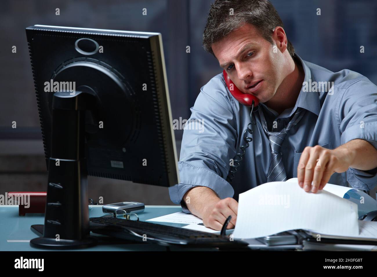 Businessman on call in overtime Stock Photo