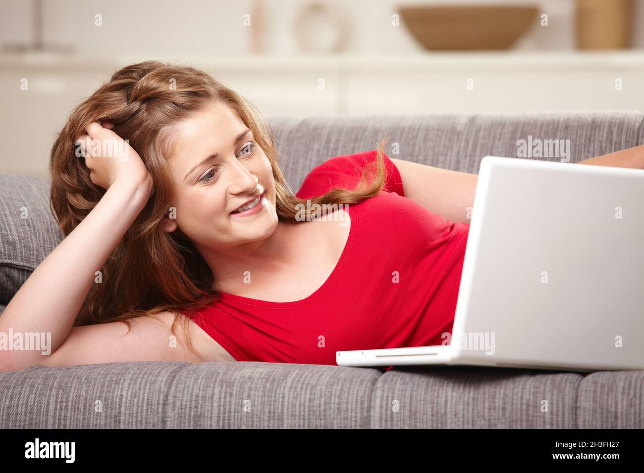 Teen girl laying on sofa hi-res stock photography and images - Alamy