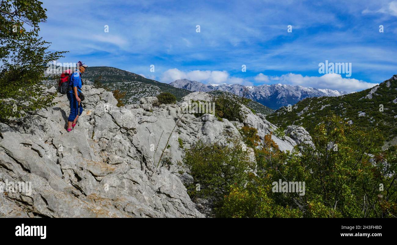 Solitary female in the Karst scenery of the Limestone mountains, Velebit mountains, Dinaric Alps, Croatia Stock Photo
