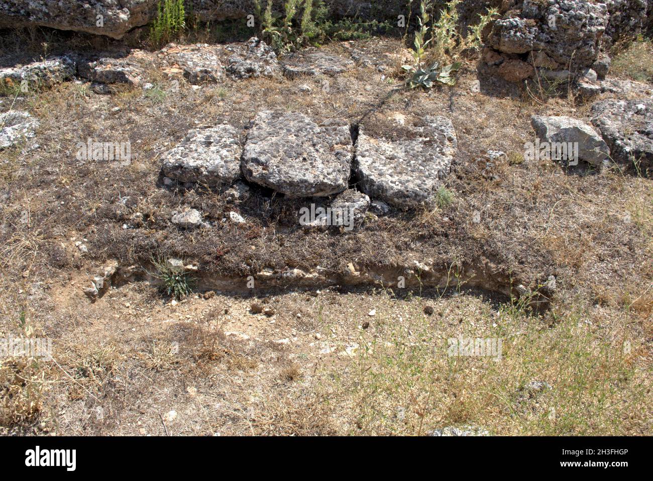 Anthropomorphic tombs excavated in rocky soil, oriented from east to west. Dating from the 10th century, located in the medieval necropolis. Stock Photo