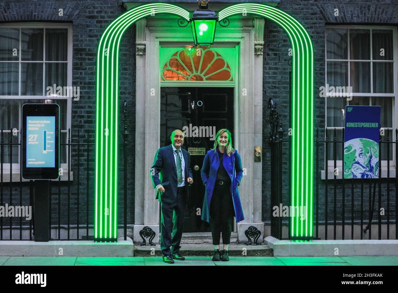 Downing Street, London, UK. 28th Oct, 2021. Allegra Stratton, spokesperson for COP26 Summit in Glasgow and President Alok Sharma, poses under the new green Downing Street light installation for the COP 26 Summit which was revealed this evening. Credit: Imageplotter/Alamy Live News Stock Photo