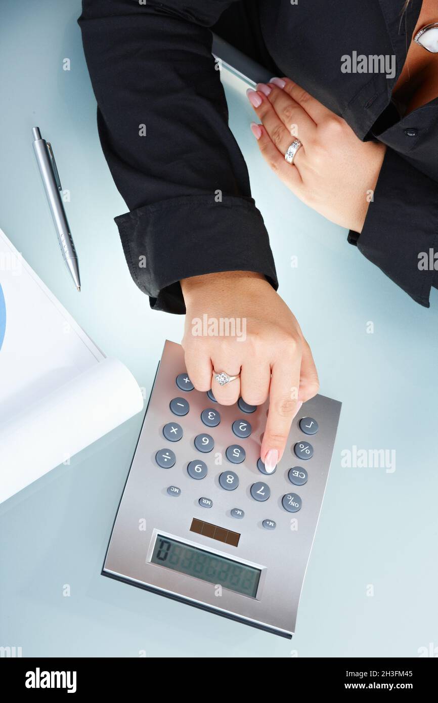 Female hands using calculator Stock Photo