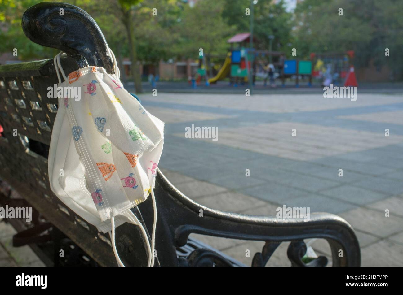 Playground bench with two face mask hooked. Covid-19 easing lockdown restrictions Stock Photo