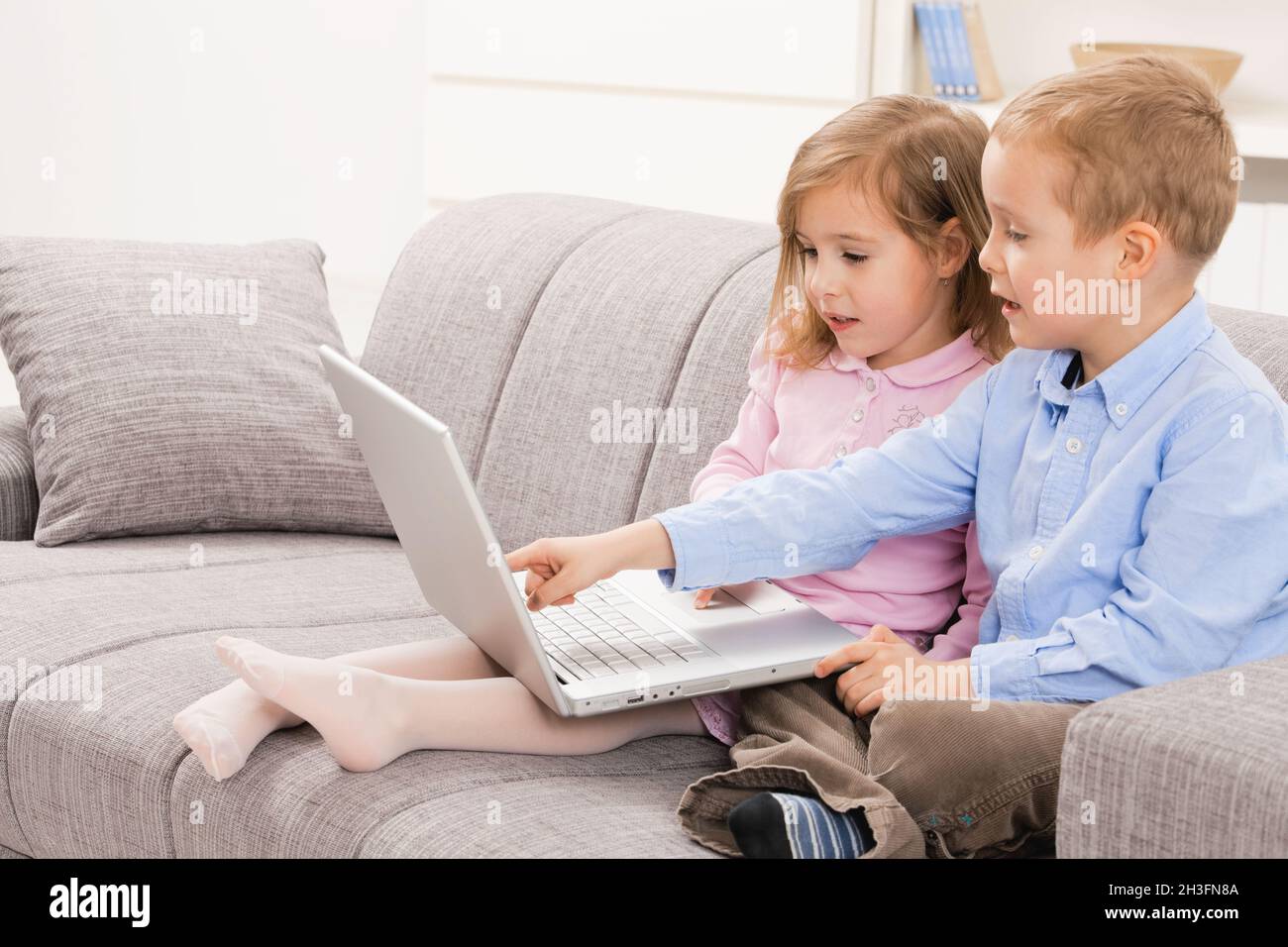 Siblings using laptop computer Stock Photo