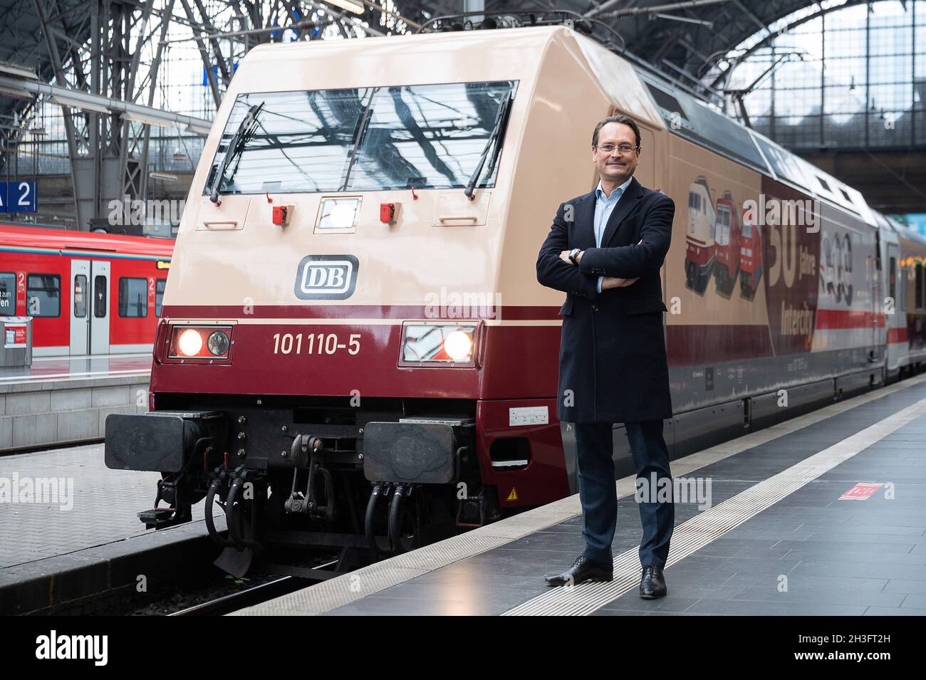 28 October 2021, Hessen, Frankfurt/Main: Michael Peterson, Chairman of the Management Board of DB Fernverkehr AG, stands in front of a class 101 locomotive with a special imprint at Frankfurt Central Station. 50 years ago, the first Intercity trains passed through Germany. A specially designed Class 101 locomotive will soon be running in front of IC trains. Photo: Sebastian Gollnow/dpa Stock Photo