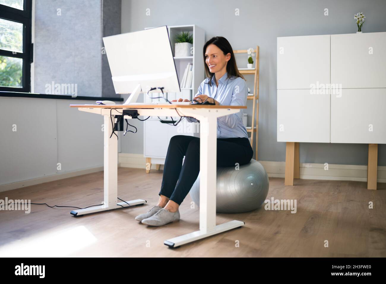 Correct Posture At Desk In Office Using Fitness Ball Stock Photo Alamy
