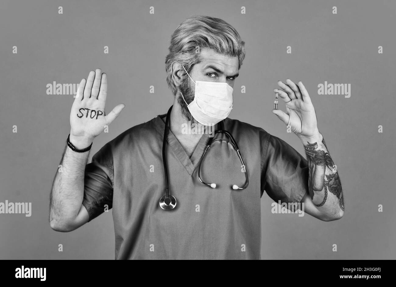 Open palm stop gesture. Critical number or density of susceptible hosts. Epidemic threshold. Man in medical lab. Protective mask. Stop epidemic. Virus Stock Photo