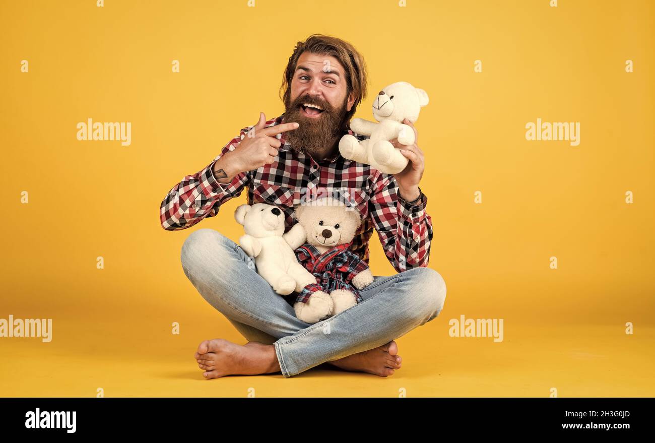 what a cute. cheerful bearded man hold teddy bear. male feel playful with bear. brutal mature hipster man play with toy. happy birthday. being in good Stock Photo