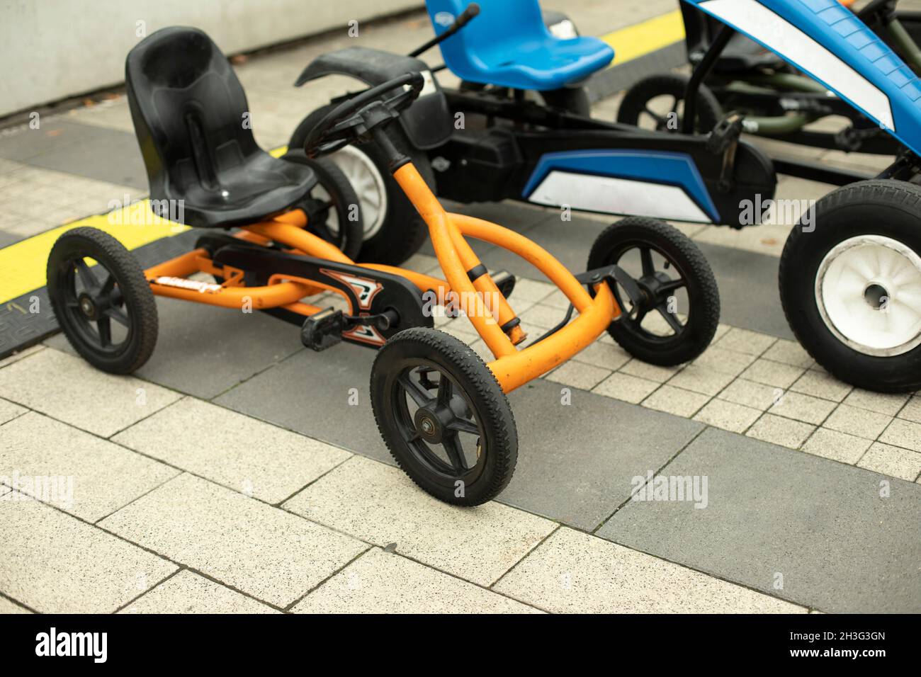 Children's transport in the park. Machines on a mechanical course. Entertaining bicycles for hire. Scooters for preschoolers. Stock Photo