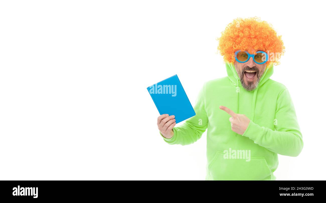 Crazy school teacher in wig and sunglasses point at blue book cover for copy space, schoolbook Stock Photo